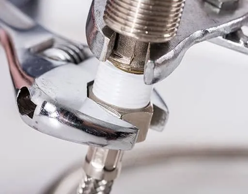 Wrench tightening a plumbing fixture